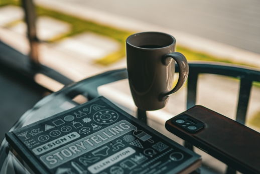 a-book--coffee-cup--and-phone-on-a-table-.jpg A book, coffee cup, and phone on a table.